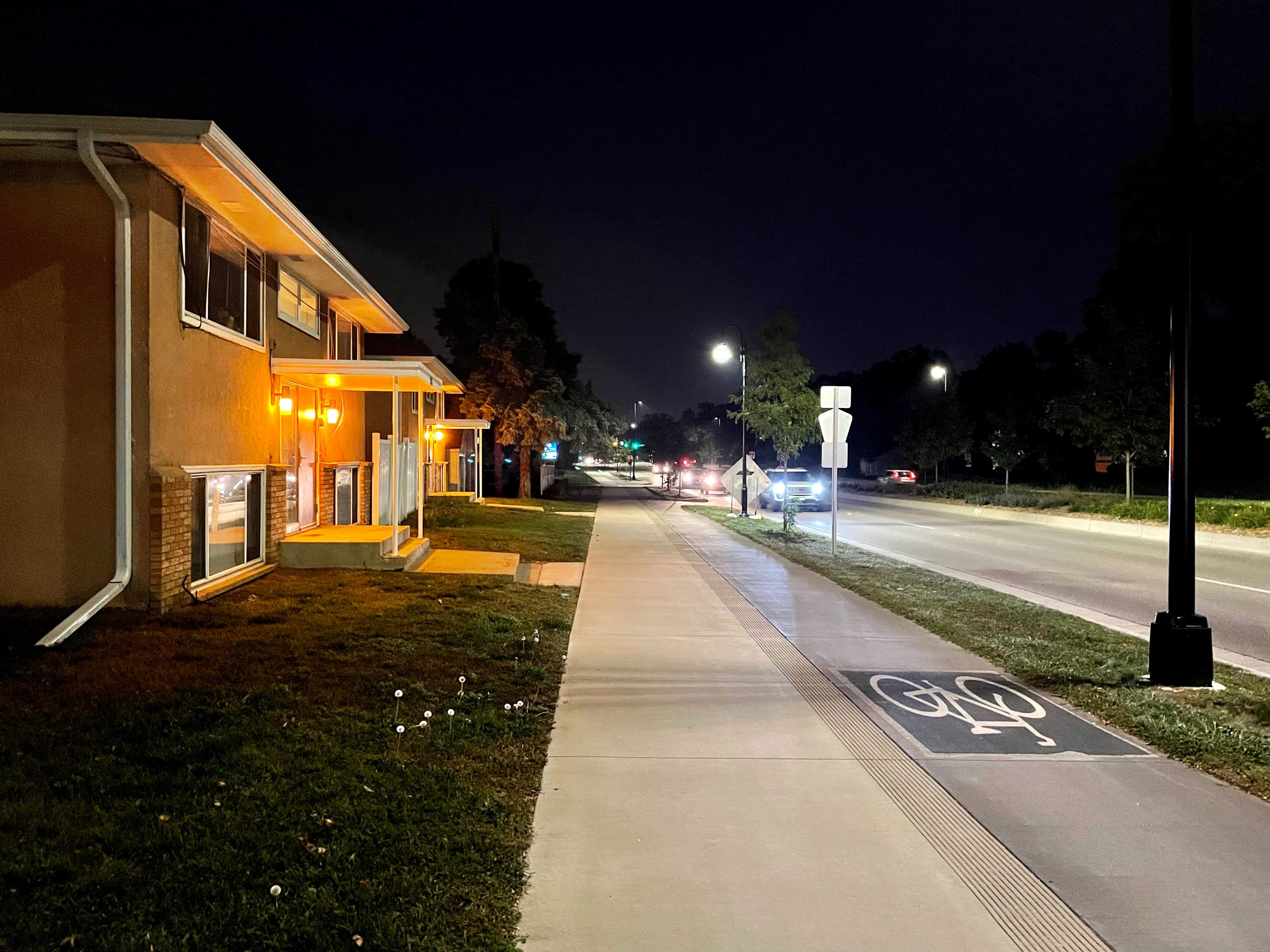 A section of the 66th Street bikeway at night, providing pleasant walking and biking to existing apartment buildings.