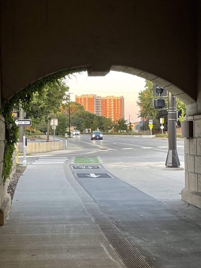 Protected bikeway and sidewalk going under I-35W at 66th Street. Downtown Richfield in background.